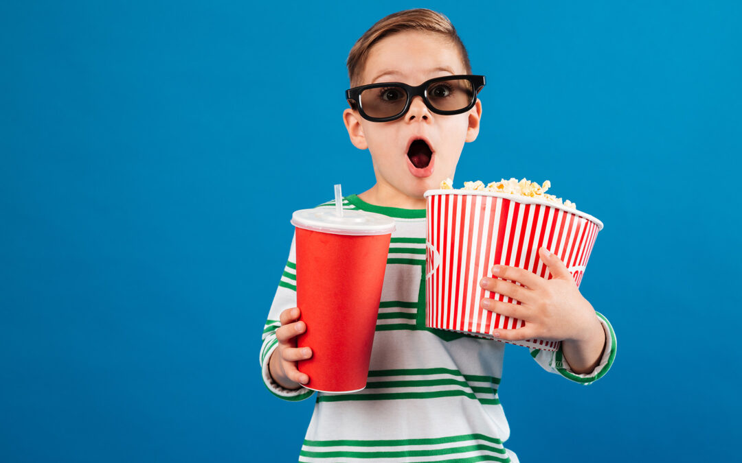 Ein erstaunter 10-Jähriger mit Popcorn und Brille!